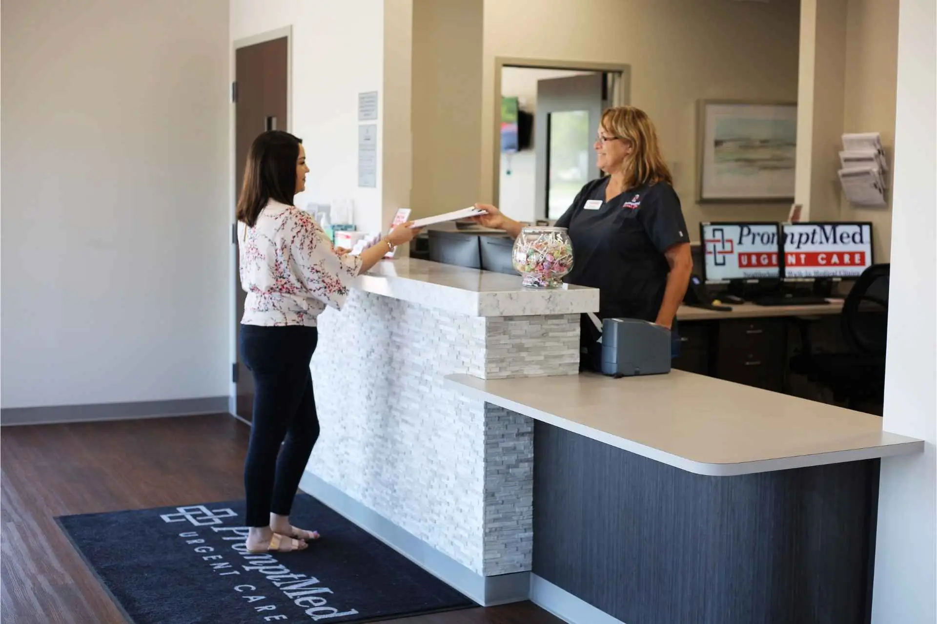 an exchange of paperwork between a patient and the receptionist