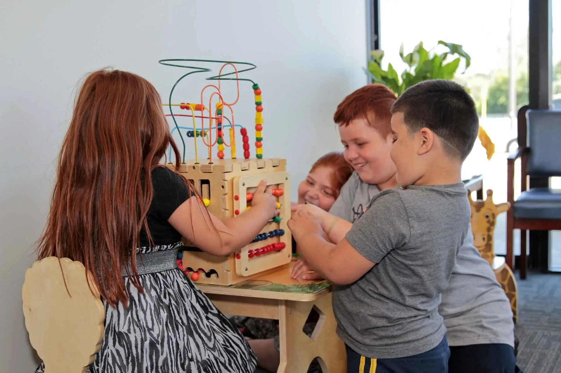 Three children playing together in the waiting room