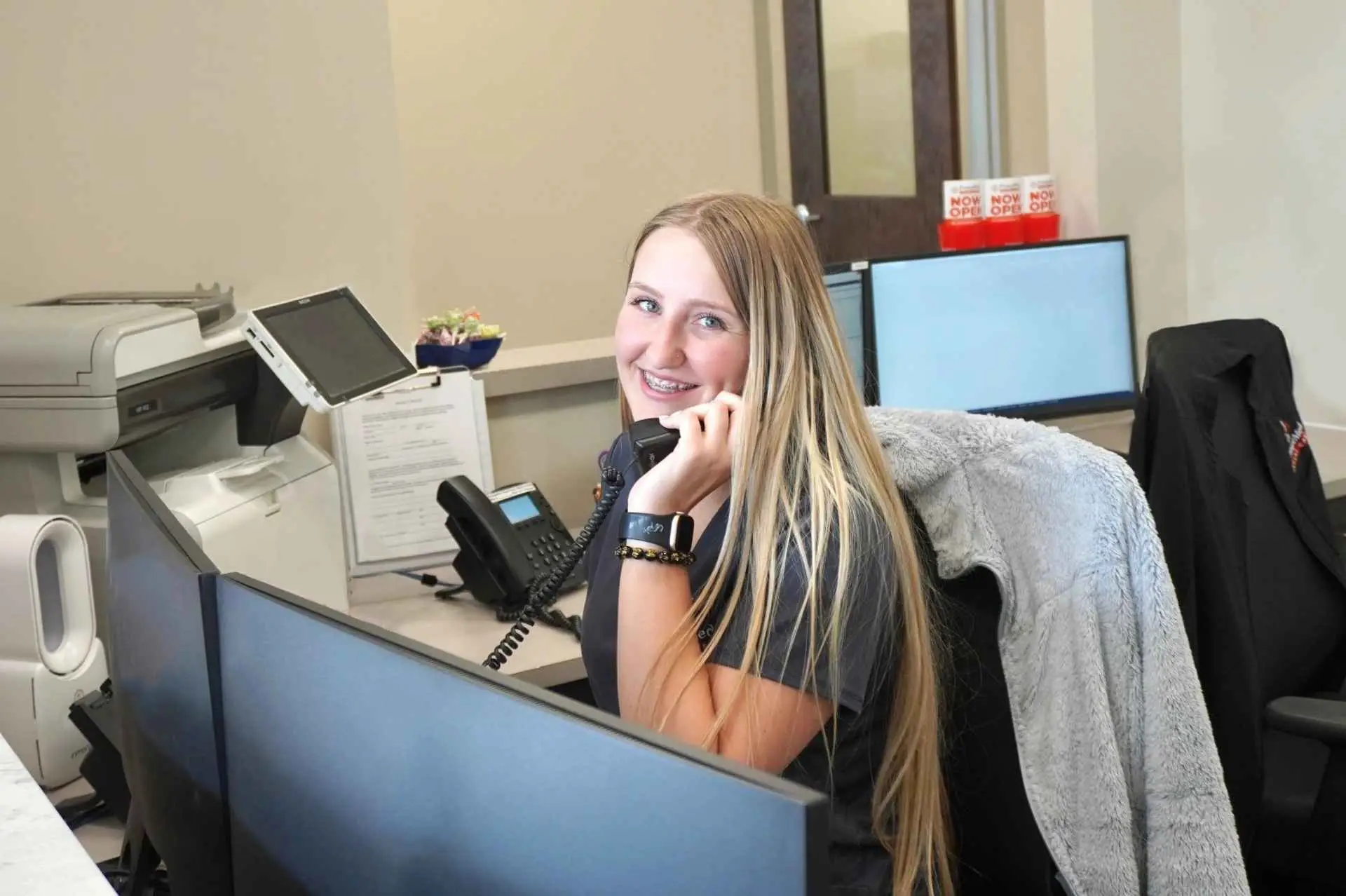 Front Desk Receptionist answering the phone at PromptMed Urgent Care